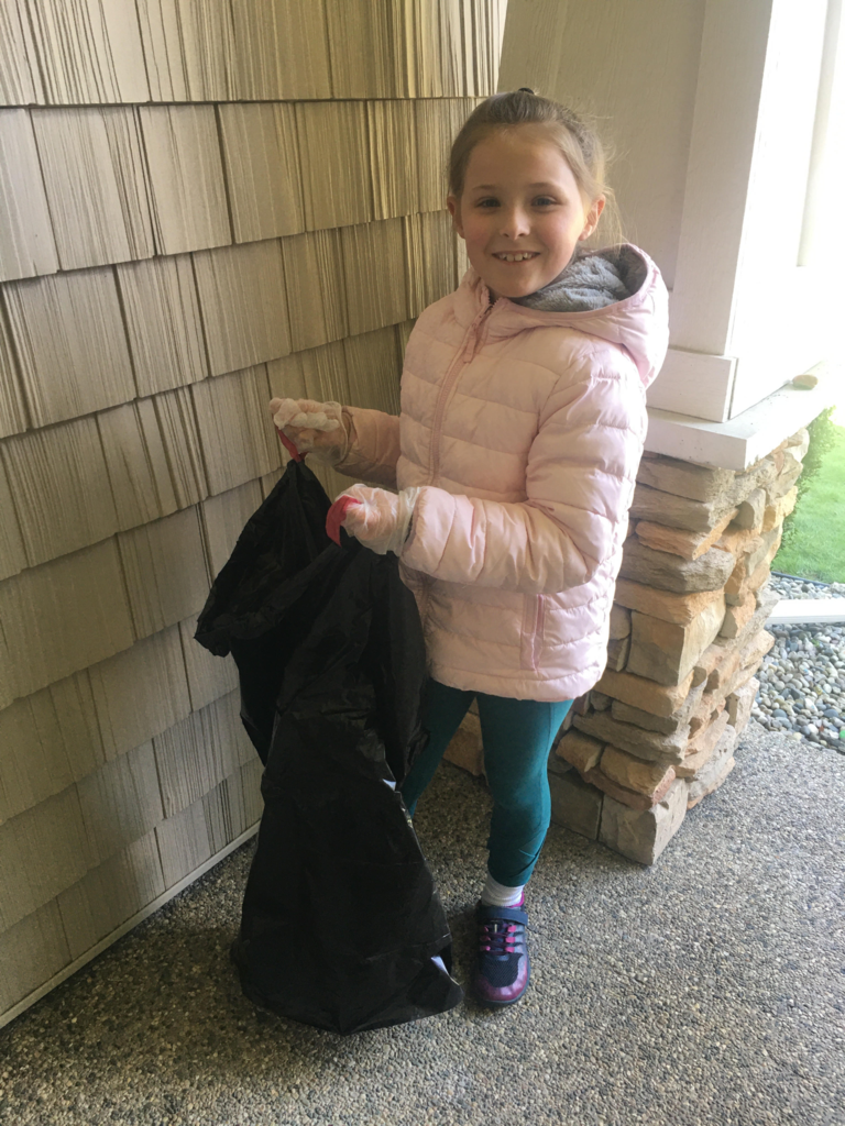 One of Ealy's virtual students taking part in Earth Day by picking up trash in her neighborhood.